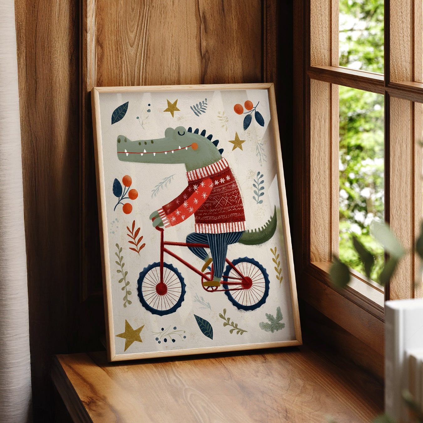 A vertical art print featuring a green crocodile riding a red bicycle. The crocodile is wearing a red and white patterned sweater and blue striped pants. The background is cream with stylized leaves, berries, and gold stars scattered around.