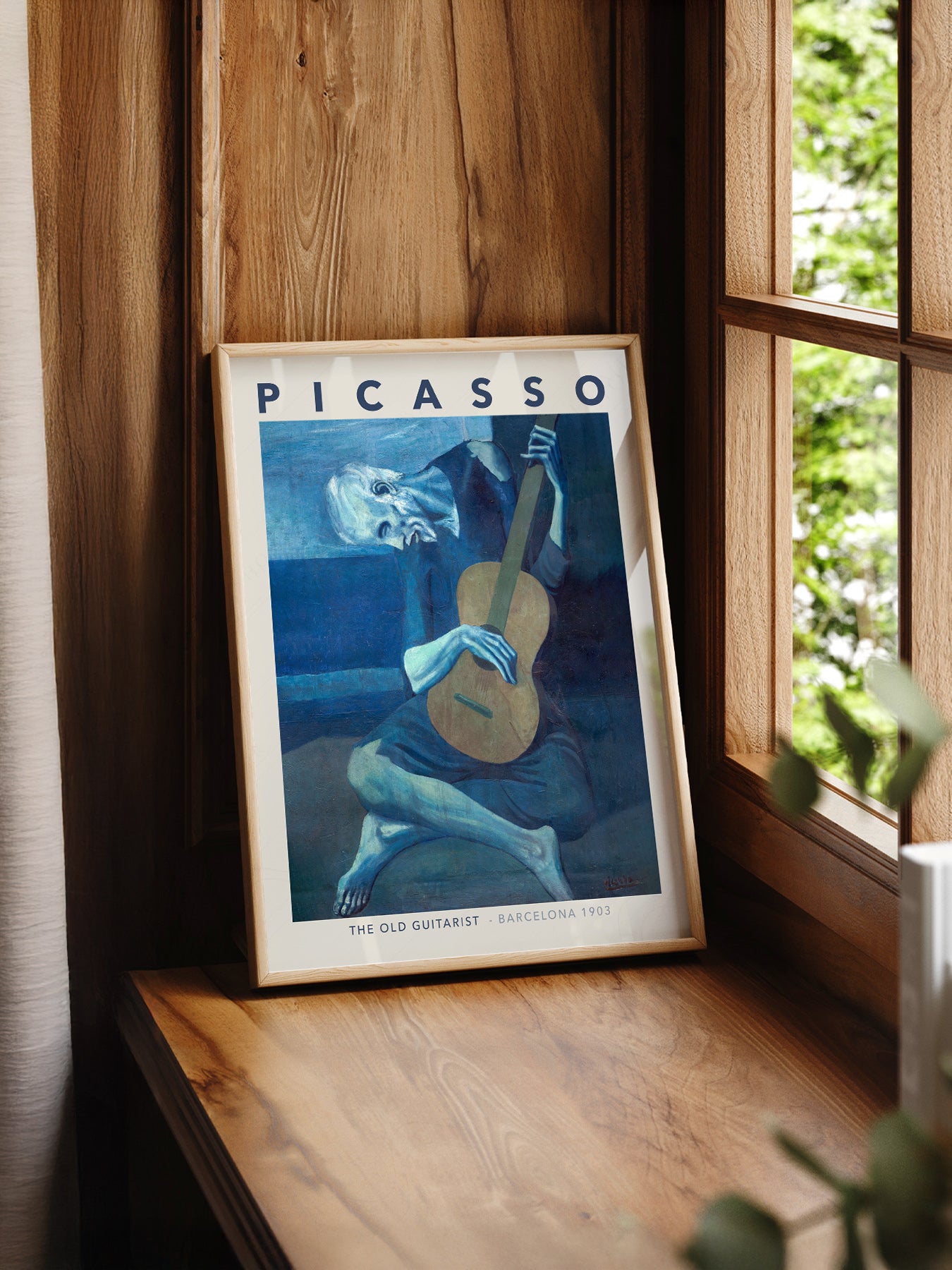 Pablo Picasso The Old Guitarist print styled in a mid-century modern dining room