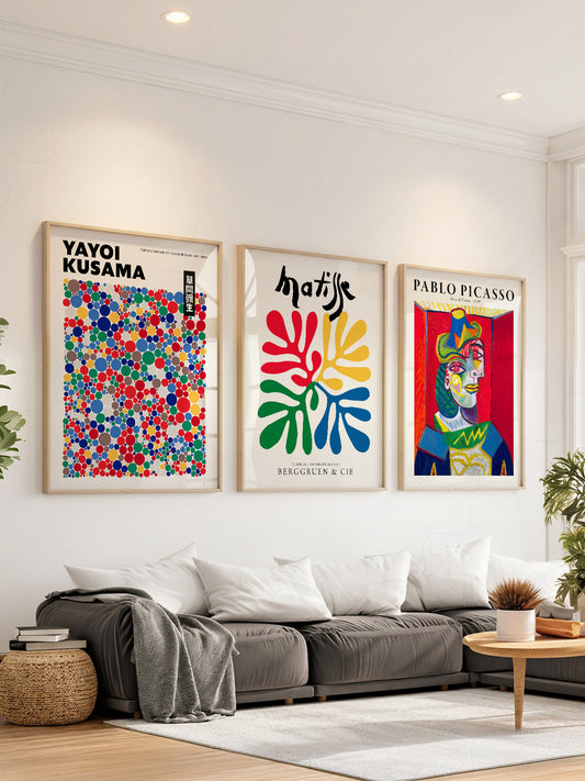 Set of three wall art prints featuring Yayoi Kusama dots, Henri Matisse cut-outs, and Pablo Picasso portrait in modern living room.