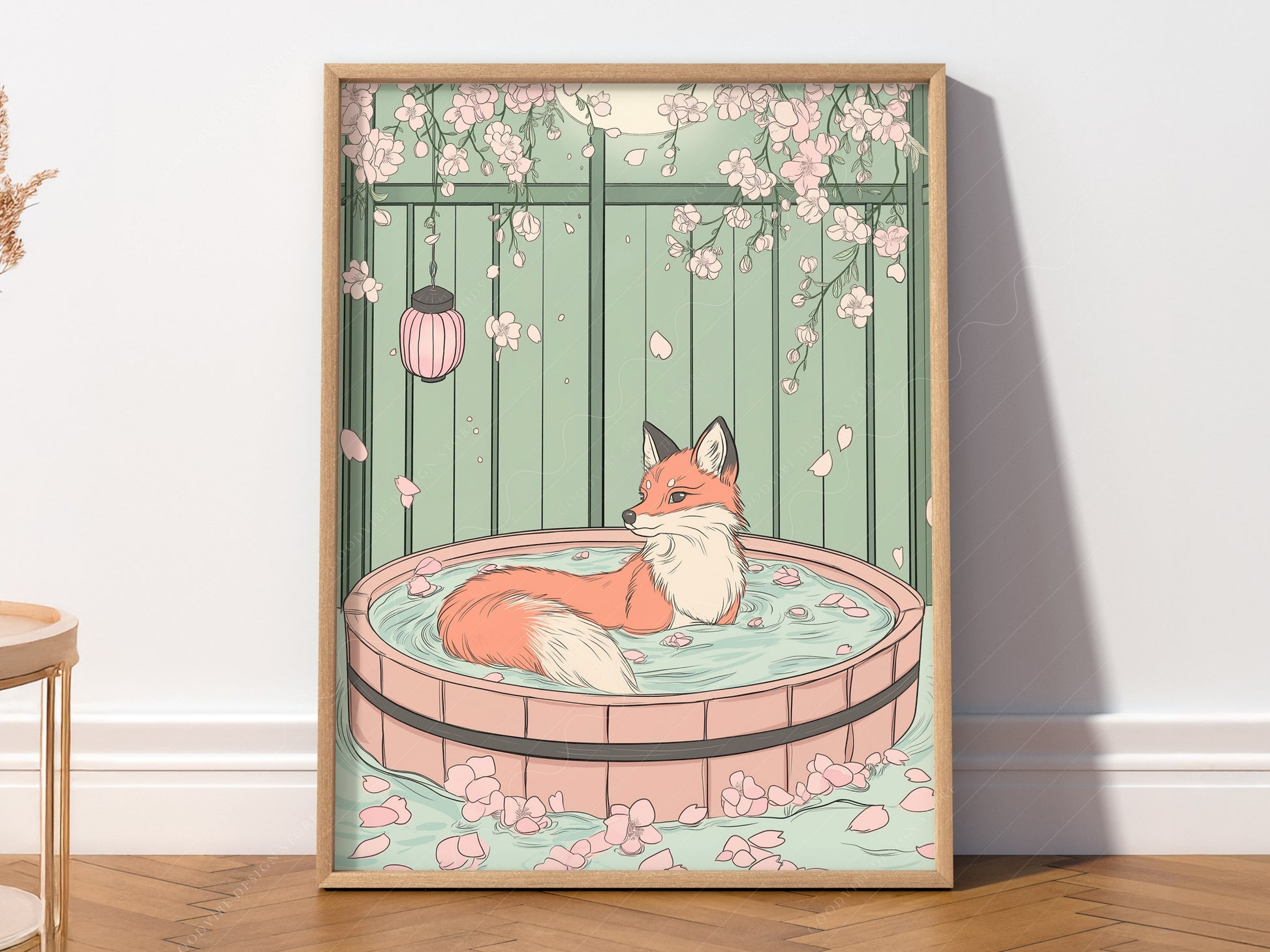 A vertical art print featuring a red fox with a white-tipped tail sitting in a circular wooden bath tub filled with water and pink petals. The background is a pale green fence with pink cherry blossoms hanging from the top and a pink lantern to the left. The scene is calm and illustrative with soft pastel colors.