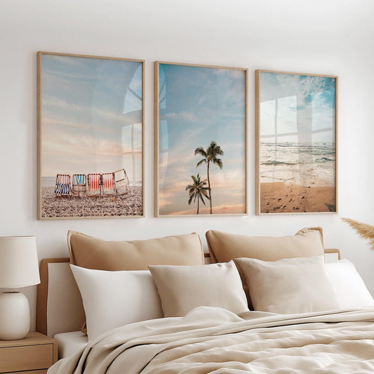 Beach wall art set of three prints featuring colorful deck chairs, palm trees, and ocean waves in a boho bedroom.