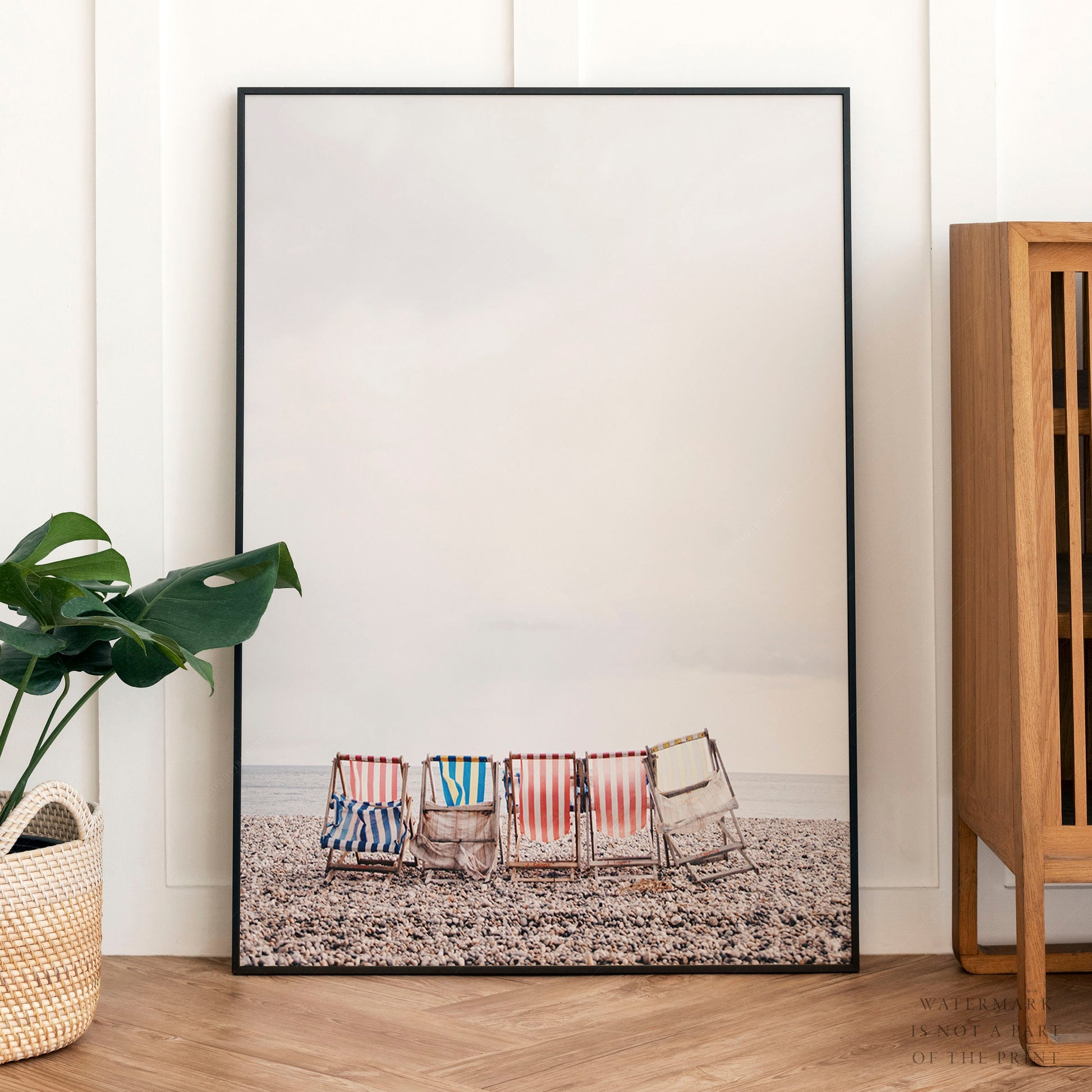 Colorful striped beach chairs on a pebble beach facing the ocean, coastal wall art print.