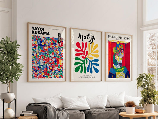 Set of three wall art prints featuring Yayoi Kusama dots, Henri Matisse cut-outs, and Pablo Picasso portrait in modern living room.