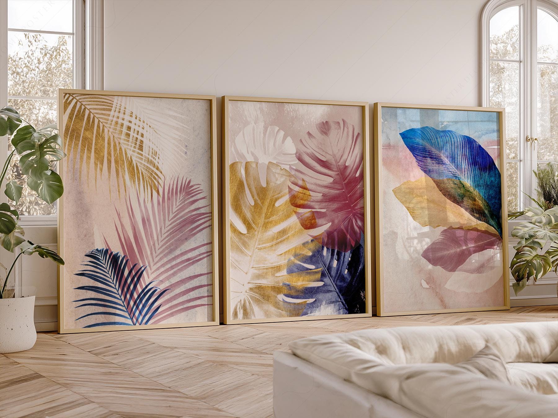 Set of three abstract tropical leaf art prints featuring palm fronds and monstera in pink, blue, and gold tones as wall art.
