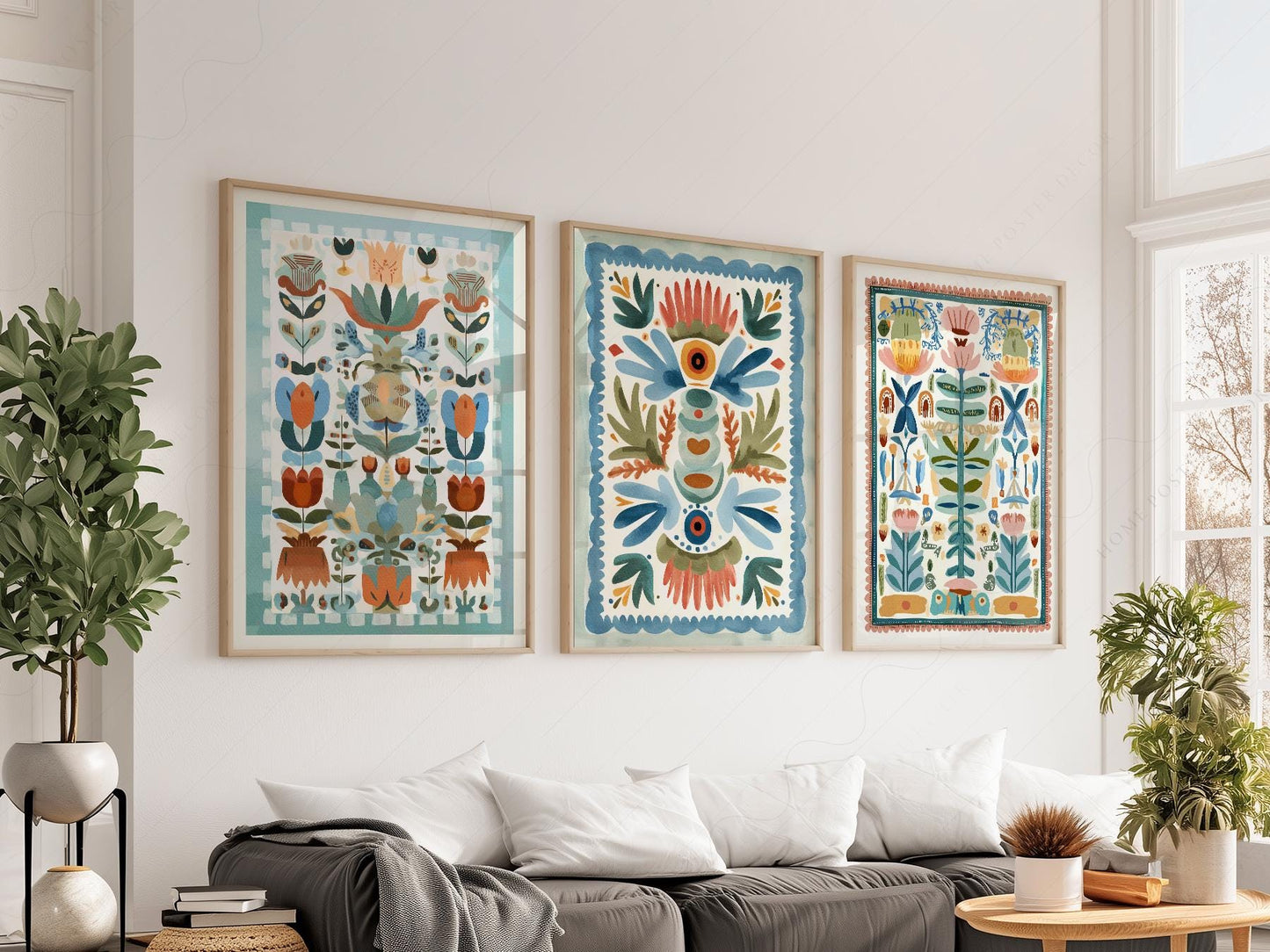 Set of three boho folk art floral prints with tapestry-style botanical designs displayed as wall art above a sofa.
