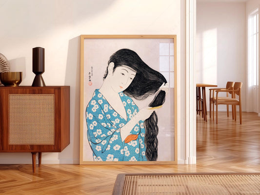 Hashiguchi Goyo Japanese woodblock art print of a woman in blue floral kimono combing her long black hair.